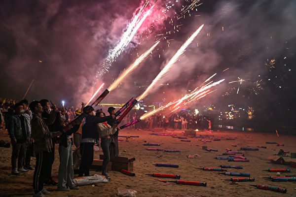 People celebrate the new year with fireworks on a bech in Houhai, in Sanya in China's southern Hainan province on January 1, 2023. (Photo by Hector RETAMAL / AFP)